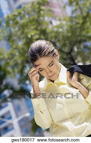 Businesswoman carrying her business suit with her hand on her forehead View Large Photo Image Stock Photo - Businesswoman carrying her business suit with her hand on her forehead. Fotosearch
