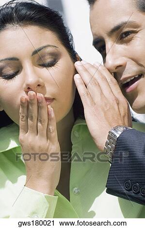 Close-up of a businessman whispering into a businesswoman's ear View Large Photo Image Stock Image - Close-up of a businessman whispering into a businesswoman's ear. Fotosearch