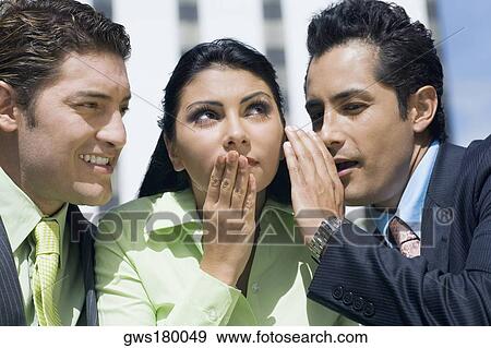 Close-up of a businesswoman gossiping with two businesswomen View Large Photo Image Stock Photo - Close-up of a businesswoman gossiping with two businesswomen. Fotosearch