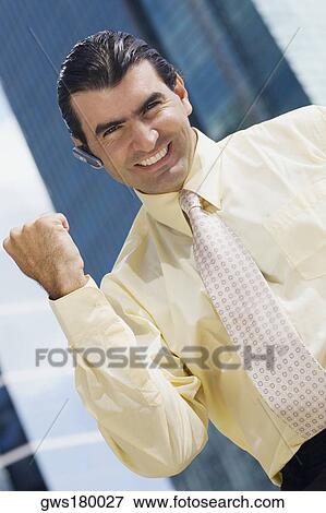 Portrait of a businessman raising his fist and smiling View Large Photo Image Stock Photo - Portrait of a businessman raising his fist and smiling. Fotosearch