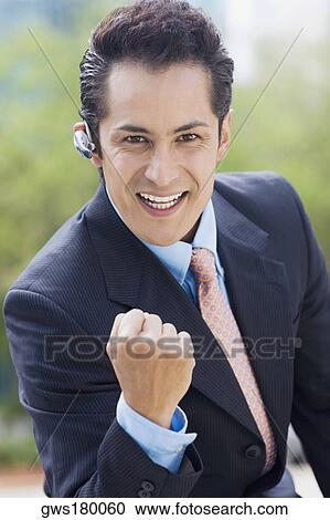 Stock Image - Portrait of a businessman showing his fist and smiling. Fotosearch