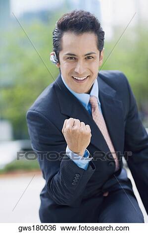 Stock Photograph - Portrait of a businessman showing his fist and smiling. Fotosearch