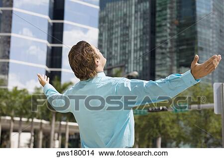 Rear view of a businessman standing with his arms outstretched View Large Photo Image Picture - Rear view of a businessman standing with his arms outstretched. Fotosearch