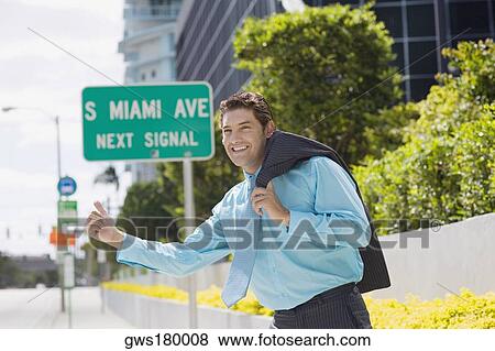Stock Photo - Side profile of a businessman hailing on the road and smiling. Fotosearch