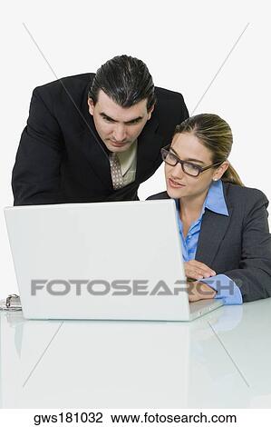 Businessman and a businesswoman using a laptop View Large Photo Image Stock Image - Businessman and a businesswoman using a laptop. Fotosearch