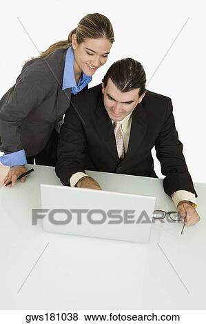 Businessman and a businesswoman using a laptop and smiling View Large Photo Image Stock Photo - Businessman and a businesswoman using a laptop and smiling. Fotosearch