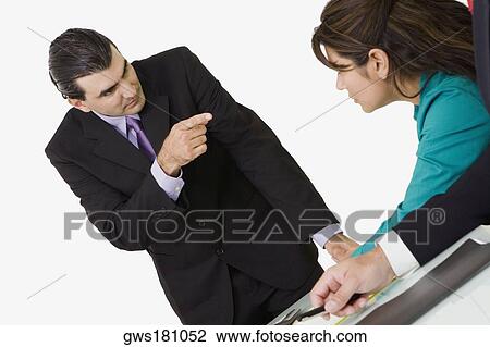 Businessman pointing at a businesswoman sitting in front of him View Large Photo Image Stock Image - Businessman pointing at a businesswoman sitting in front of him. Fotosearch