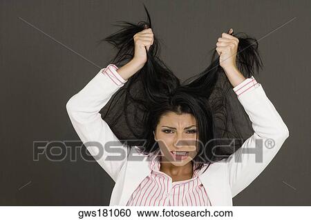 Close-up of a young woman pulling her hair View Large Photo Image Stock Image - Close-up of a young woman pulling her hair. Fotosearch