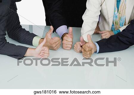 Stock Photograph - Five business executives showing thumbs up sign in a meeting. Fotosearch