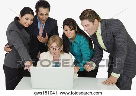 Four business executives surrounding a businesswoman working on a laptop View Large Photo Image Stock Image - Four business executives surrounding a businesswoman working on a laptop. Fotosearch