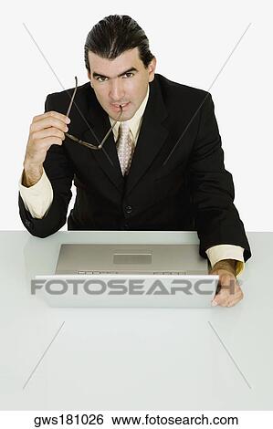 Portrait of a businessman holding his eyeglasses and thinking View Large Photo Image Stock Photograph - Portrait of a businessman holding his eyeglasses and thinking. Fotosearch