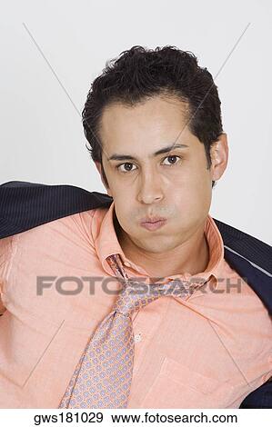 Portrait of a businessman putting off his coat View Large Photo Image Stock Photo - Portrait of a businessman putting off his coat. Fotosearch