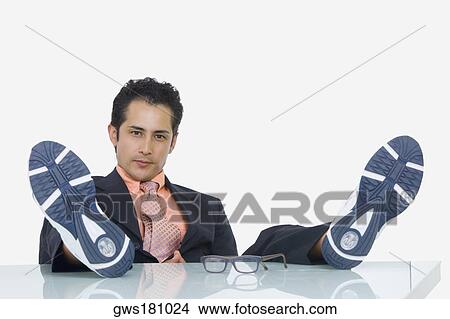 Portrait of a businessman resting with his feet up in an office View Large Photo Image Picture - Portrait of a businessman resting with his feet up in an office. Fotosearch