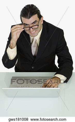 Portrait of a businessman using a laptop and smiling View Large Photo Image Stock Photo - Portrait of a businessman using a laptop and smiling. Fotosearch