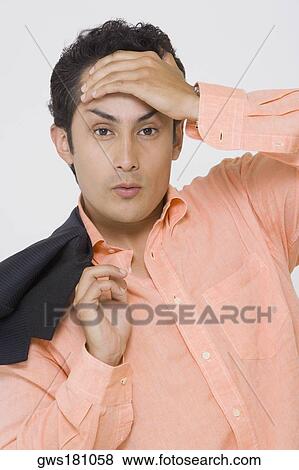 Stock Photo - Portrait of a young man suffering from a headache. Fotosearch
