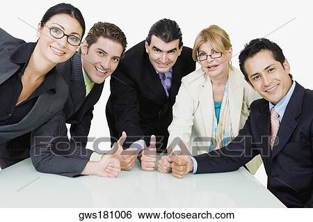 Stock Photograph - Portrait of five business executives showing thumbs up sign in a meeting. Fotosearch