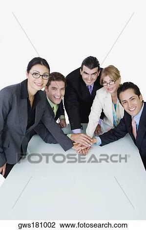 Portrait of two businesswomen and three businessmen placing their hands on each other View Large Photo Image Stock Image - Portrait of two businesswomen and three businessmen placing their hands on each other. Fotosearch