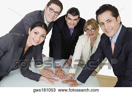 Portrait of two businesswomen and three businessmen placing their hands on the table View Large Photo Image Stock Image - Portrait of two businesswomen and three businessmen placing their hands on the table. Fotosearch