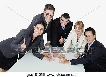 Portrait of two businesswomen and three businessmen placing their hands on the table View Large Photo Image Stock Photograph - Portrait of two businesswomen and three businessmen placing their hands on the table. Fotosearch