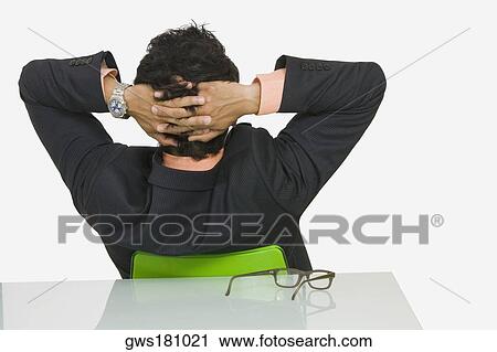 Rear view of a businessman sitting with his hands behind his head View Large Photo Image Stock Image - Rear view of a businessman sitting with his hands behind his head. Fotosearch