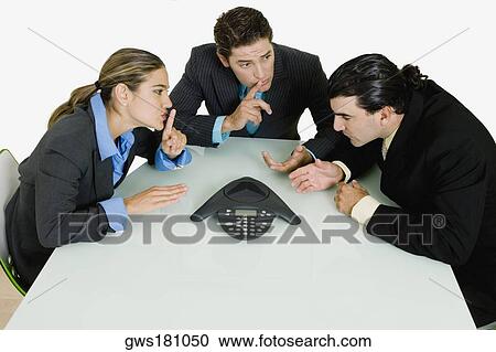 Two businessmen and a businesswoman having a telephone conference in a boardroom View Large Photo Image Stock Image - Two businessmen and a businesswoman having a telephone conference in a boardroom. Fotosearch