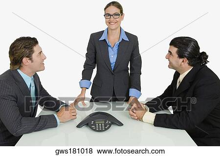 Two businessmen and a businesswoman smiling in a board room View Large Photo Image Stock Photo - Two businessmen and a businesswoman smiling in a board room. Fotosearch