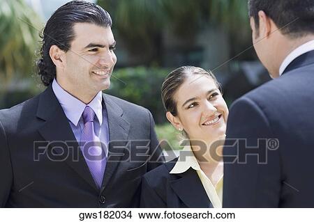 Picture - Business executives talking to each other and smiling. Fotosearch