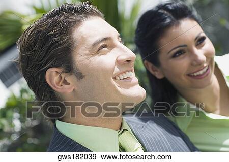 Close-up of a businessman smiling with a businesswoman View Large Photo Image Stock Photo - Close-up of a businessman smiling with a businesswoman. Fotosearch