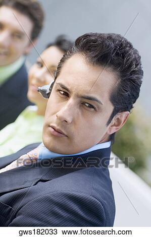 Stock Image - Close-up of a businessman wearing a hands free device. Fotosearch