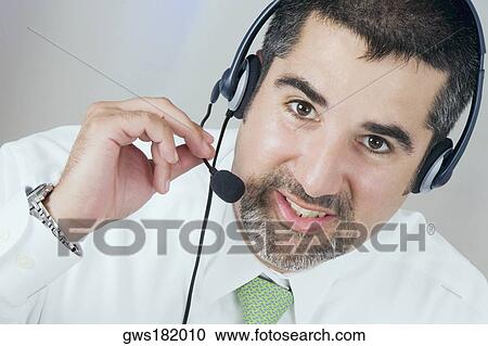 Stock Image - Close-up of a male customer service representative wearing a headset. Fotosearch