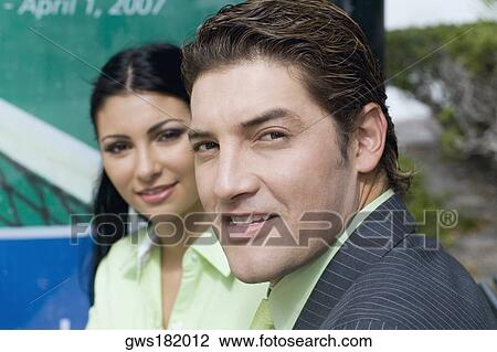 Stock Image - Portrait of a businessman and a businesswoman smiling. Fotosearch