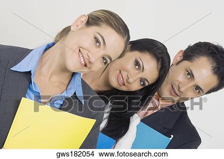 Picture - Portrait of a businessman and two businesswomen smiling and holding files. Fotosearch
