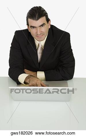 Stock Photograph - Portrait of a businessman using a laptop. Fotosearch
