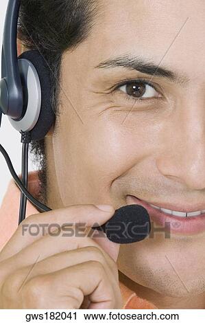 Stock Image - Portrait of a businessman wearing a headset and smiling. Fotosearch