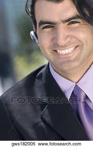Portrait of a businessman wearing a hands free device and smiling View Large Photo Image Stock Photography - Portrait of a businessman wearing a hands free device and smiling. Fotosearch