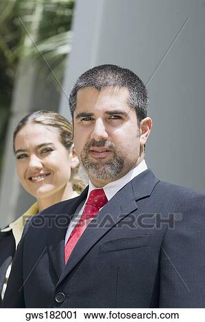 Portrait of a businessman with a businesswoman smiling behind him View Large Photo Image Stock Image - Portrait of a businessman with a businesswoman smiling behind him. Fotosearch