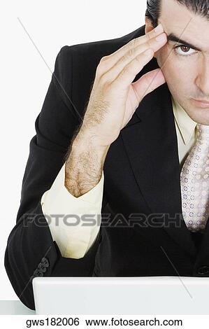 Stock Photograph - Portrait of a businessman with his head in his hands thinking. Fotosearch