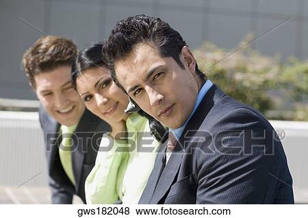 Stock Photo - Portrait of a businesswoman smiling with two businessmen. Fotosearch