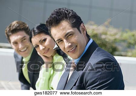 Portrait of a businesswoman smiling with two businessmen View Large Photo Image Stock Photo - Portrait of a businesswoman smiling with two businessmen. Fotosearch