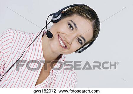 Stock Image - Portrait of a businesswoman wearing a headset and smiling. Fotosearch