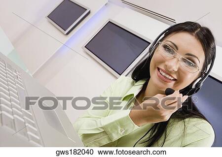 Portrait of a customer service representative talking on a headset View Large Photo Image Stock Image - Portrait of a customer service representative talking on a headset. Fotosearch