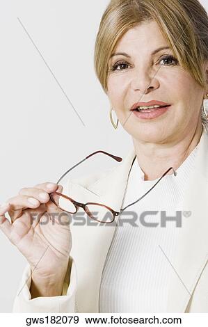Portrait of a mature woman holding eyeglasses View Large Photo Image Stock Photo - Portrait of a mature woman holding eyeglasses. Fotosearch
