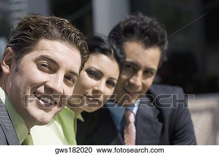 Portrait of two businessmen and a businesswoman smiling View Large Photo Image Stock Image - Portrait of two businessmen and a businesswoman smiling. Fotosearch