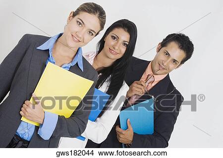 Portrait of two businesswomen and a businessman holding files and smiling View Large Photo Image Picture - Portrait of two businesswomen and a businessman holding files and smiling. Fotosearch