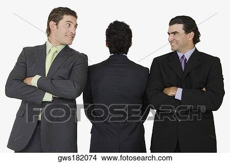 Rear view of a businessman standing with two businessmen with their arms crossed View Large Photo Image Picture - Rear view of a businessman standing with two businessmen with their arms crossed. Fotosearch