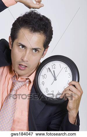 Close-up of a businessman holding a noose and a clock View Large Photo Image Stock Photo - Close-up of a businessman holding a noose and a clock. Fotosearch