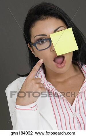 Close-up of a businesswoman looking shocked and pointing towards an adhesive note View Large Photo Image Stock Image - Close-up of a businesswoman looking shocked and pointing towards an adhesive note. Fotosearch