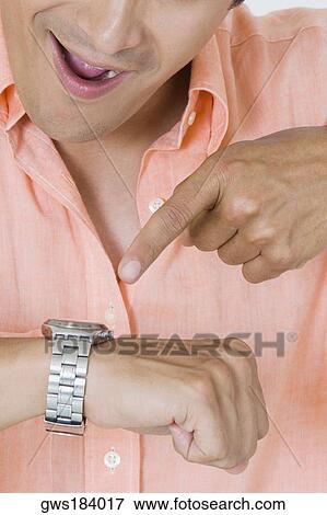Close-up of a young man checking the time View Large Photo Image Stock Photo - Close-up of a young man checking the time. Fotosearch