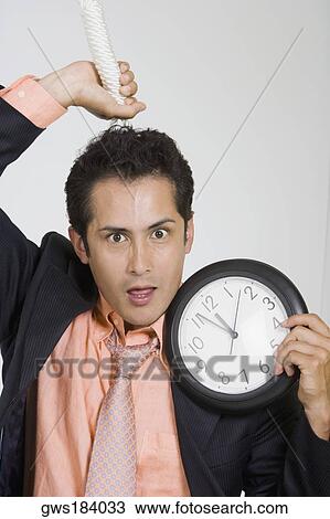 Portrait of a businessman holding a noose and a clock View Large Photo Image Stock Image - Portrait of a businessman holding a noose and a clock. Fotosearch