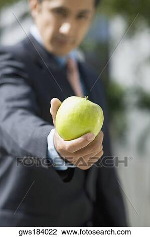 Portrait of a businessman showing a granny smith apple View Large Photo Image Stock Image - Portrait of a businessman showing a granny smith apple. Fotosearch